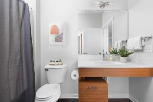 a white bathroom with a toilet and a sink at The Pendleton Boutique Stylish 1 bedroom Condo in Traverse City +29 photos