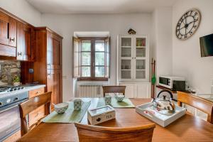 a kitchen with a table and a clock on the wall at GuestHost - Lavanda Apartment with Pool & Parking in Passignano sul Trasimeno