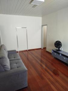a living room with a couch and a wooden floor at Casa da Nona in Garibaldi