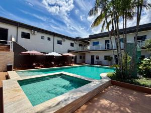 a swimming pool in front of a building at Villa's Boraceia in Boracéia