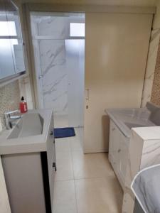 a white bathroom with a sink and a shower at Casa da Nona in Garibaldi