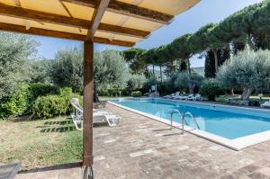 a swimming pool with a table and chairs next to it at GuestHost - Lavanda Apartment with Pool & Parking in Passignano sul Trasimeno