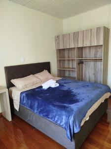a bedroom with a large bed with a blue blanket at Casa da Nona in Garibaldi