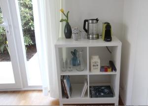 a white shelf with a blender on it next to a door at Zimmer am Ring - ruhiges Zimmer im Grünen, Frühstück auf eigener Terrasse mit Morgensonne und fußläufig zum Badeplatz Schwarzindien am Mondsee in Sankt Lorenz