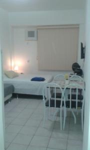 1 dormitorio con 1 cama, mesa y sillas en Copacabana Studio One, en Río de Janeiro