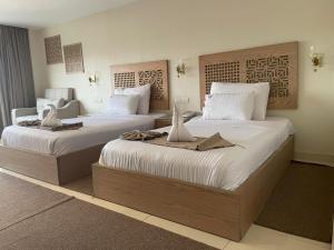two beds in a hotel room with towels on them at DouDou Pyramids View Hotel in Cairo