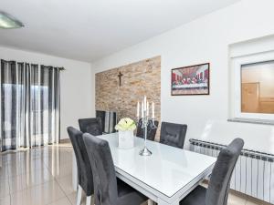 a dining room with a white table and chairs at Apartment Dijana by Interhome in Donji Proložac