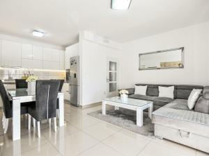 a white living room with a couch and a table at Apartment Dijana by Interhome in Donji Proložac