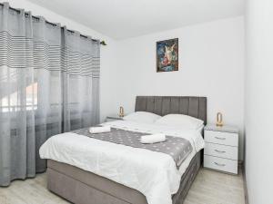 a bedroom with a large bed and a window at Apartment Dijana by Interhome in Donji Proložac