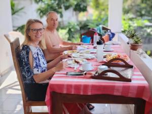 a man and a woman sitting at a table with food at Villa Sasindu in Koggala