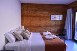 a bedroom with a bed with towels on it at Hosteria Manzano Amargo in Manzano Amargo