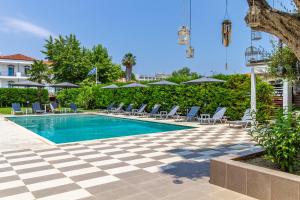 a swimming pool with lounge chairs and umbrellas at Oikos in Hanioti
