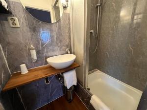a bathroom with a sink and a bath tub at Hotel Galleria in Munich +48 photos