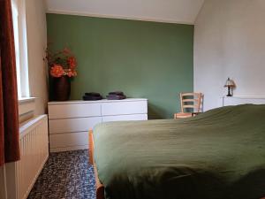 a bedroom with a bed and a green wall at Voorhuis 2 personen - De Kruidenhoeve in het Reestdal - in Balkbrug