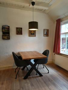 a dining room with a wooden table and two chairs at Voorhuis 2 personen - De Kruidenhoeve in het Reestdal - in Balkbrug