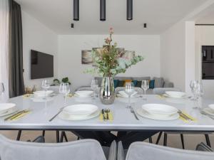 a white table with white plates and a vase with flowers at Villa Magic Sky 1 by Interhome in Kraj
