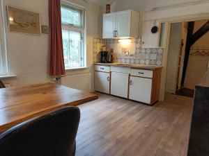 a kitchen with a wooden table and a wooden floor at Voorhuis 2 personen - De Kruidenhoeve in het Reestdal - in Balkbrug