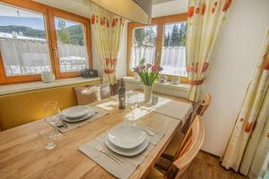 a dining room with a table with chairs and windows at Ferienwohnung Bergblick in Filzmoos +47 photos