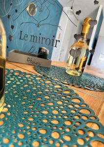 a bottle of wine sitting on a table next to a bottle of cookies at Le miroir des désirs in Argentré-du-Plessis +23 photos