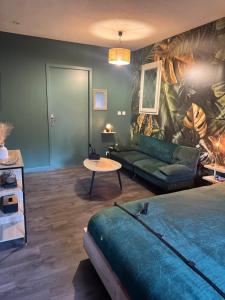 a living room with a bed and a couch at Le miroir des désirs in Argentré-du-Plessis