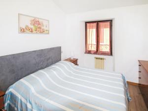 a bedroom with a large bed with a window at Apartment Amarena by Interhome in Dormelletto