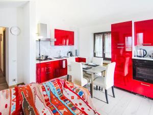 a kitchen with red cabinets and a table with chairs at Apartment Amarena by Interhome in Dormelletto +8 photos