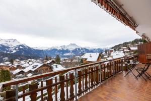 a balcony with a view of snow covered mountains at Alpine Hygge by Villars Luxury in Villars-sur-Ollon