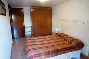 - une chambre avec un lit et une porte en bois dans l'établissement Apartamentos Turísticos Río Gallego (Apartamento Huesca), à Huesca