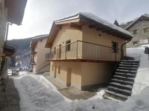 a building with a balcony and stairs in the snow at Coudrey 2 in Doues