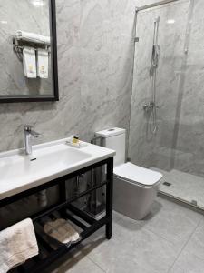 a bathroom with a toilet and a sink and a shower at Loren Hotel in Tashkent +18 photos