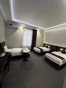 a hotel room with two beds and a table at Loren Hotel in Tashkent