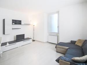 a white living room with a couch and a tv at Apartment Le Gemme-3 by Interhome in Meina