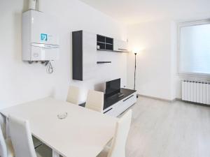 a white dining room with a white table and chairs at Apartment Le Gemme-3 by Interhome in Meina