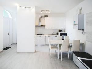 a white kitchen with a table and chairs at Apartment Le Gemme-3 by Interhome in Meina +20 photos
