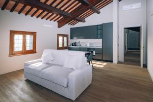 a living room with a white couch and a kitchen at Legnago Suite Apartments in Legnago