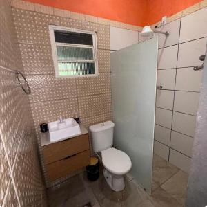 a bathroom with a toilet and a sink and a window at Your Climatized Paradise in Americana +8 photos