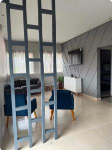 a living room with blue chairs and a ladder at Your Climatized Paradise in Americana