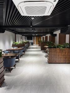 a dining room with tables and chairs and plants at Loren Hotel in Tashkent