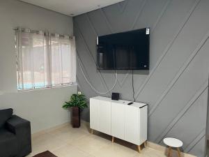 a living room with a tv on a wall at Your Climatized Paradise in Americana