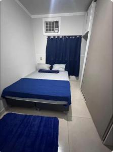 a bedroom with a bed with blue sheets and a window at Your Climatized Paradise in Americana