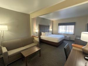 a hotel room with a bed and a couch at Best Western Plus Paper Valley Hotel in Appleton +7 photos