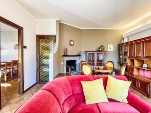 a living room with a red couch and a dining room at Apartment Carlui by Interhome in Domaso