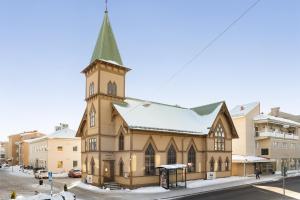 a church with a green steeple on a street at Best Western Hotel Bollnas in Bollnäs