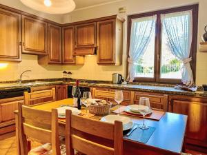 a kitchen with a table with chairs and a bottle of wine at Apartment Carlui by Interhome in Domaso