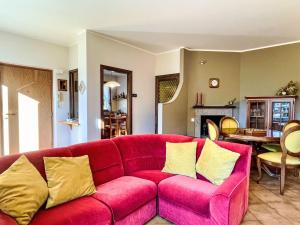 a red couch with yellow pillows in a living room at Apartment Carlui by Interhome in Domaso