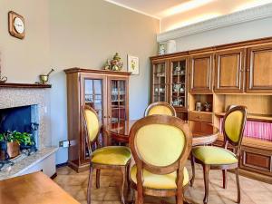 a dining room with a table and chairs and a fireplace at Apartment Carlui by Interhome in Domaso