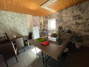 a kitchen with two sinks and a table with chairs at Gästehaus Back - Reisfelder Hof in Reinsfeld