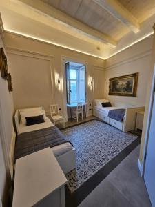 a hotel room with two beds and a table at Portus Noir Valletta in Valletta