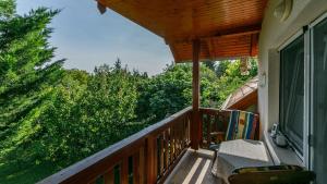 a balcony with a table and chairs and trees at Mézi Lazy in Gyenesdiás +5 photos