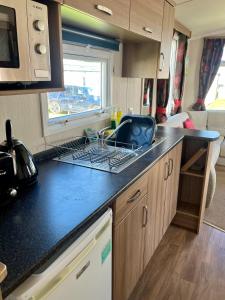 a kitchen with a black counter top in a caravan at Sea Salt in Padstow +5 photos